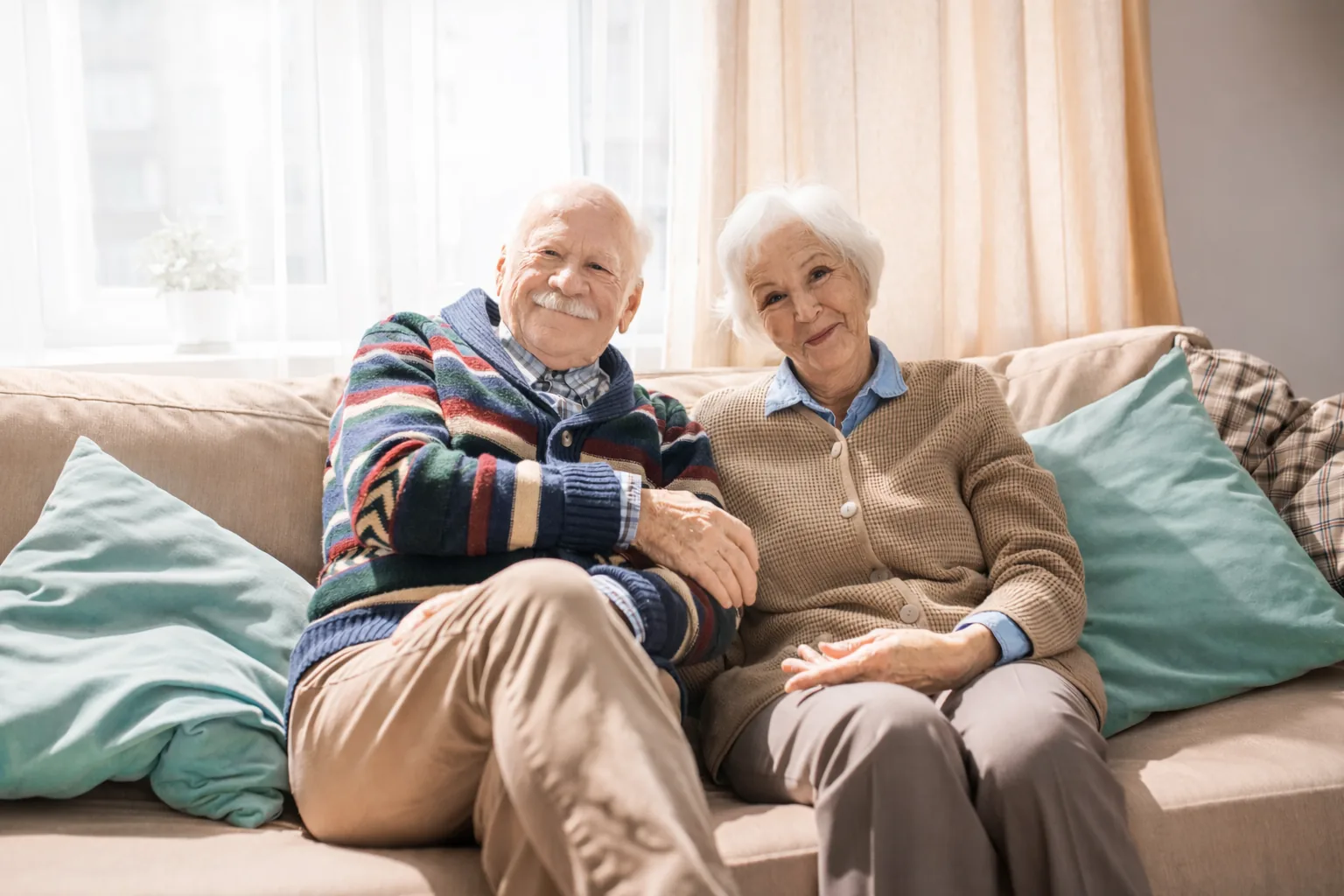 Older couple sitting together at home, talking over tea