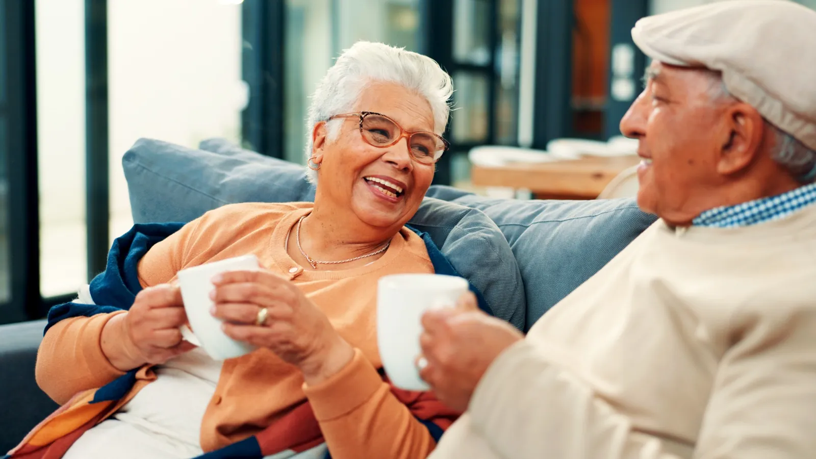 Older couple sitting together at home, talking over tea